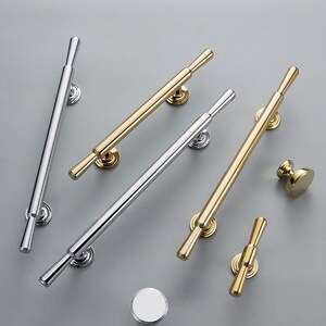 Peut inclure: Un ensemble de cinq poignées de porte en or et argent. Les poignées sont toutes longues et fines avec une extrémité arrondie. Deux des poignées sont en or et trois sont en argent.