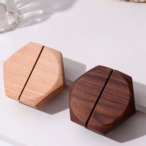 Könnte beinhalten: Zwei sechseckige Serviettenhalter aus Holz. Einer ist hellbraun und der andere dunkelbraun.
