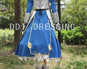 May include: A blue and silver costume with a skirt, bodice, and boots. The costume is inspired by a popular anime character. The costume is on a mannequin in a garden setting.