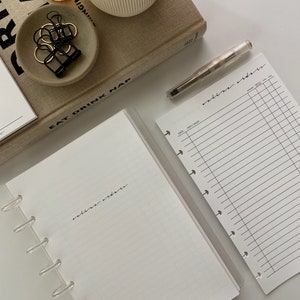 May include: A white planner with a clear plastic binder and a gridded page. The page is labeled "online orders".