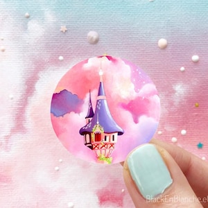 May include: A purple and pink watercolor illustration of a fairytale tower in the clouds. The tower has a pointed roof and a small window. The clouds are pink and white, and the background is a light blue.