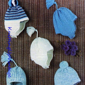 May include: Five knitted baby hats in blue and white with ear flaps. The hats have different styles, including a striped hat with a pom-pom, a hat with a tassel, and a hat with a cable knit pattern.