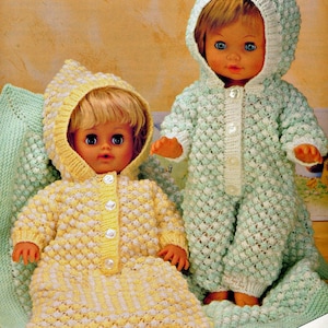 May include: Two knitted doll outfits with hoods, one in yellow and white and the other in green and white. The outfits are made with a textured stitch and have button closures. The text "FOR DOLLS AND PREMATURE BABIES" is at the bottom of the image.