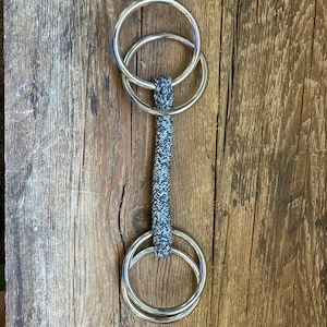 Bocado de cuero o cuerda de doble anilla