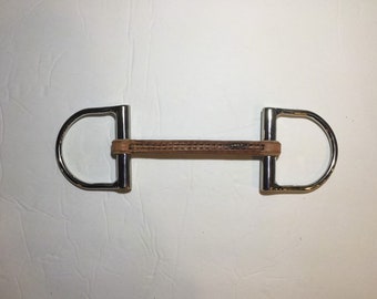 May include: A silver horse bit with a brown leather mouthpiece. The bit has two D-shaped rings at either end.