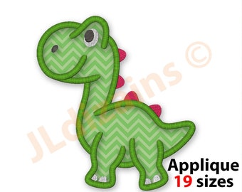 May include: Green dinosaur applique with a chevron pattern. The dinosaur has a pink nose and pink spots on its back. Applique is available in 19 sizes.