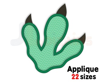May include: A green dinosaur footprint applique with a zigzag pattern, outlined in dark green, and featuring brown claws. The text "Applique 22 sizes" is displayed in red and black. The logo "JL Dizains" is at the bottom.