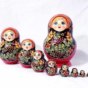 May include: A set of 9 traditional Russian nesting dolls, also known as Matryoshka dolls. The dolls are painted in a vibrant red, black, and gold color scheme with intricate floral designs. The largest doll is about 10 inches tall and the smallest is about 1 inch tall.