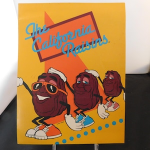 May include: A yellow and orange background with the text "The California Raisins" in blue and white. Three cartoon raisins are wearing sunglasses and shoes. The raisins are smiling and have their arms outstretched.