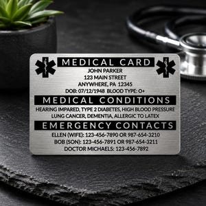 May include: A silver medical card with black text and a black medical symbol. The card includes the name John Parker, address, date of birth, blood type, medical conditions, and emergency contact information.