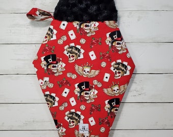 May include: Red fabric stocking with a black faux fur cuff. The stocking features a repeating pattern of playing cards, skulls, and roses. The text "Playing for Keeps" is printed on the stocking.