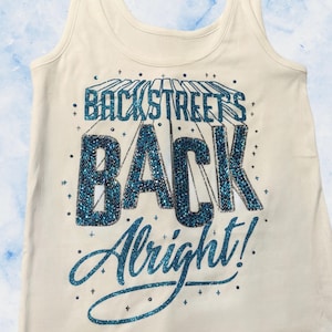 May include: Cream-colored tank top with the text "BACKSTREET'S BACK Alright!" in sparkling blue glitter. The text is arranged in a stylized design with a retro aesthetic. The tank top has a ribbed texture.