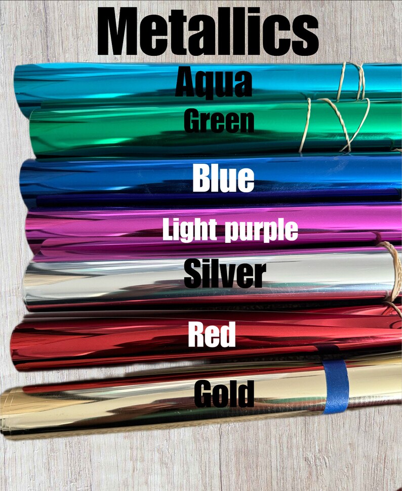 May include: A stack of seven metallic rolls of vinyl in various colours, including aqua, green, blue, light purple, silver, red, and gold. The rolls are labelled with their respective colours.