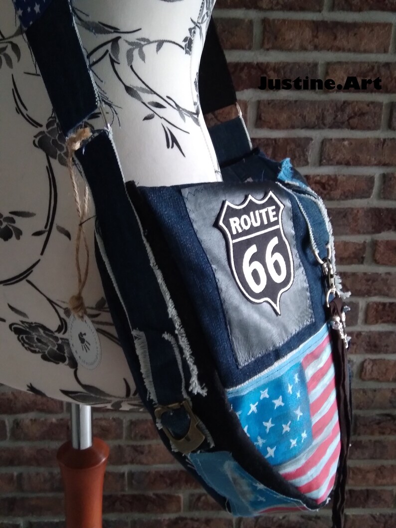 Puede incluir: Un bolso bandolera de patchwork de mezclilla azul y bandera estadounidense con un parche de la Ruta 66. El bolso tiene una correa larga ajustable y un cierre de cremallera.