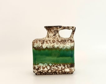 May include: A rectangular ceramic vase with a handle, featuring a textured brown and white top section, a vibrant green stripe in the middle, and a speckled brown base. The vase has a unique, artistic design, suitable for home decor.