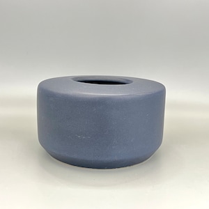Puede incluir: Un pequeño jarrón de cerámica gris redondo con un acabado liso y mate.