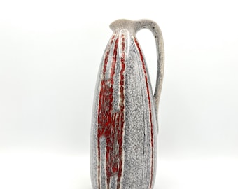 May include: A ceramic pitcher with a gray and red striped design. The pitcher has a wide mouth and a handle.
