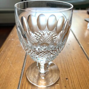 May include: A clear glass goblet with a cut crystal design. The goblet has a wide bowl and a tall stem with a round base.