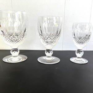 May include: Three clear glass goblets with a diamond pattern on the bowl and stem. The goblets are arranged in a row from largest to smallest.