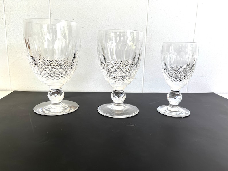 May include: Three clear glass goblets with a diamond pattern on the bowl and stem. The goblets are arranged in a row from largest to smallest.