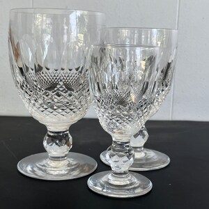 May include: Three clear glass goblets with a diamond pattern. The goblets are of different sizes, with the largest goblet in the back and the smallest goblet in the front.