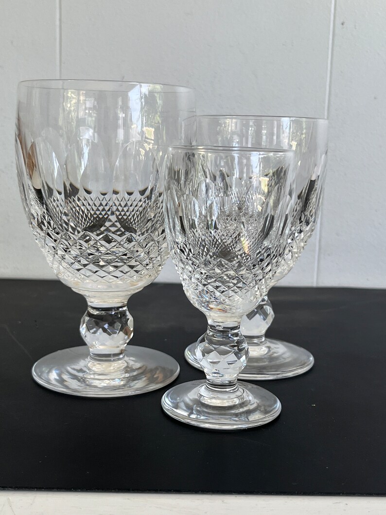 May include: Three clear glass goblets with a diamond pattern. The goblets are of different sizes, with the largest goblet in the back and the smallest goblet in the front.