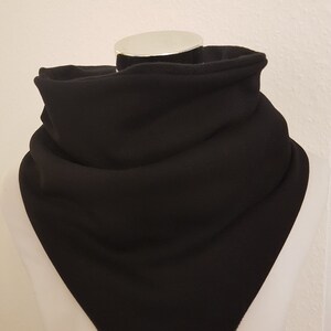 Może przedstawiać: Czarny polarowy komin lub szal. Komin jest złożony i prezentowany na białym manekinie.