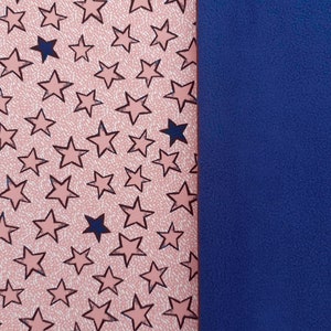 Op de afbeelding: Een roze stof met een patroon van donkerblauwe sterren. De stof is genaaid aan een effen blauwe stof.