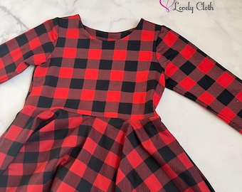 May include: A long-sleeved dress featuring a red and black buffalo plaid pattern. The dress has a round neckline and a flared skirt. The text "Lovely Cloth" is visible in the upper right corner.