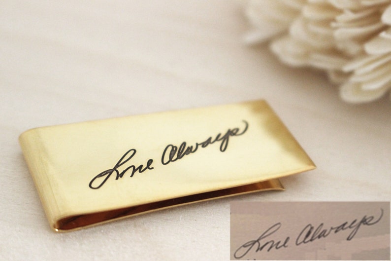 May include: A gold-colored money clip with the inscription "Love Always" engraved in black.