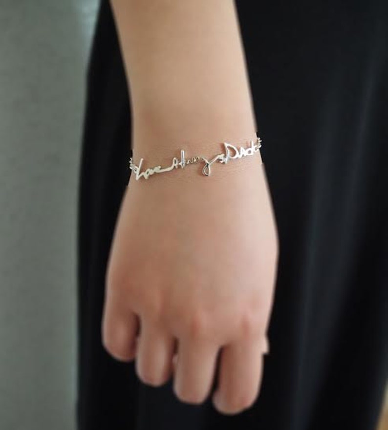 May include: Silver bracelet with the words "Love always Dad" written in cursive.