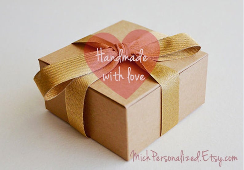 May include: A brown cardboard gift box tied with a gold ribbon and a pink heart sticker that says "Handmade with love".