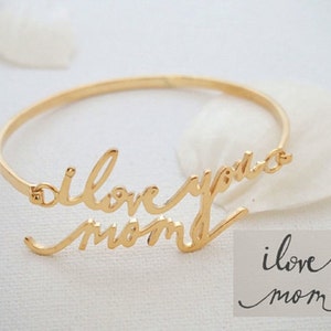 May include: Gold bangle bracelet with the words "i love you mom" written in cursive.