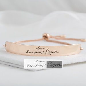 以下が含まれることがあります： 「Love Grandma & Papa」と刻まれた、ローズゴールドのブレスレットです。