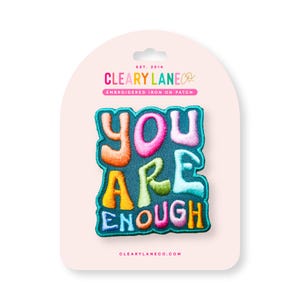 May include: A colorful embroidered iron-on patch with the text "You Are Enough" in a retro font style. The patch is on a pink background with the brand name "Cleary Lane Co." and the text "Embroidered Iron On Patch".