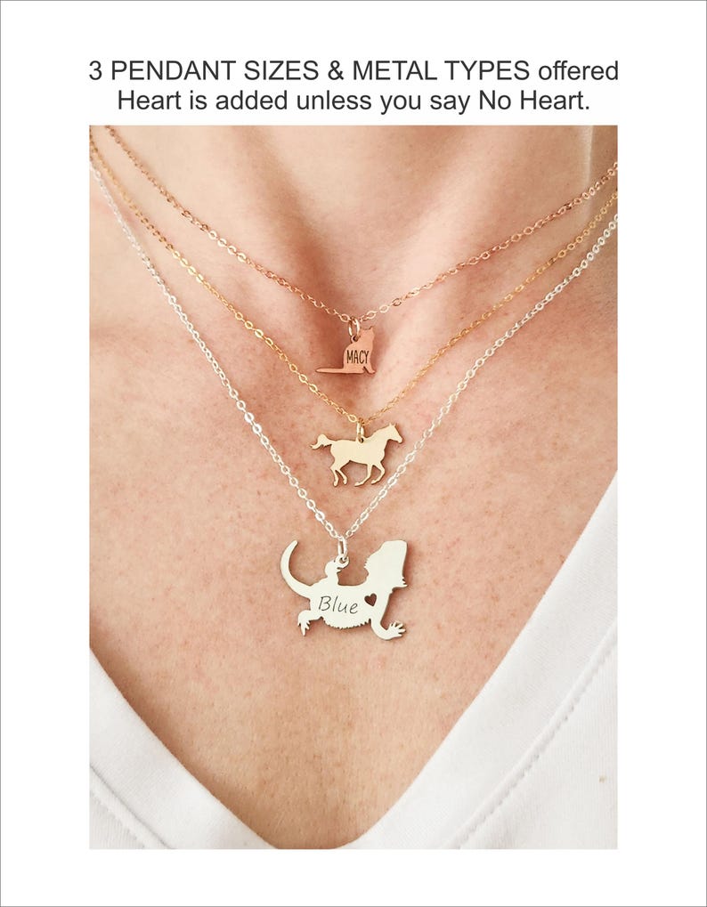 Model is shown with white shirt wearing a rose gold cat necklace, gold running horse necklace, and silver bearded dragon necklace, engraved with the name Blue.  All pendants are different sizes. All chains are different lengths for a layered look.