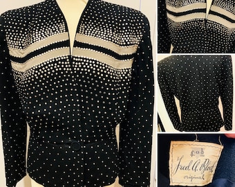 May include: A black blazer with silver sequins and two horizontal bands of silver fabric. The blazer has a V-neck and a single button closure. The label reads "Fred A. Block Original".