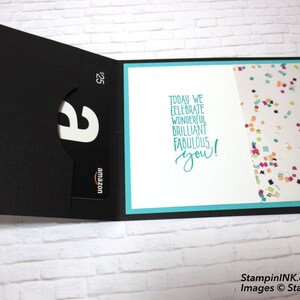 May include: A black gift card holder with an Amazon gift card visible. The card holder is open, revealing a white interior with the text "Today we celebrate wonderful brilliant fabulous you!" and a confetti pattern.
