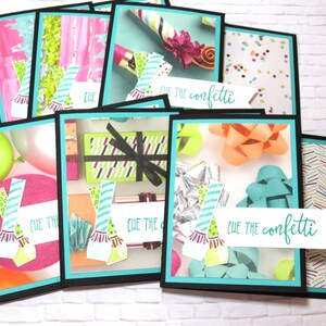 May include: A collection of colorful greeting cards with a black border and a teal inner border. The cards feature birthday-themed designs, including balloons, confetti, gift boxes, and bows. The phrase "Cue the confetti" is written on a white banner.