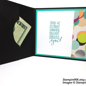 May include: Black greeting card with a pocket holding a twenty-dollar bill. The inside features the teal text "Today we celebrate wonderful brilliant fabulous you!" and a patterned paper with colorful confetti.