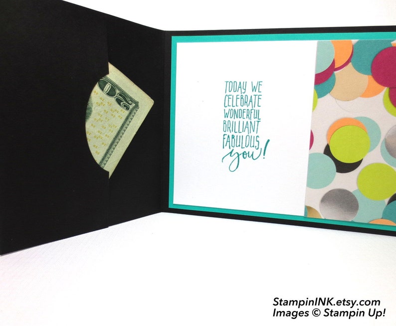 May include: Black greeting card with a pocket holding a twenty-dollar bill. The inside features the teal text "Today we celebrate wonderful brilliant fabulous you!" and a patterned paper with colorful confetti.