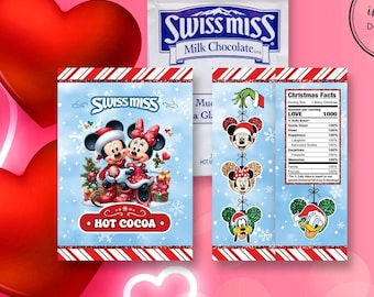 May include: A festive hot cocoa packet featuring Mickey and Minnie Mouse in holiday attire, with the text "HOT COCOA." A packet of Swiss Miss Milk Chocolate is also visible. The design includes snowflakes and a candy cane stripe.