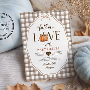 May include: A rectangular baby shower invitation card with a brown and white buffalo check border. The text reads fall in love with BABY OLIVIA, October 12, and includes event details. A small orange pumpkin illustration replaces the letter O.