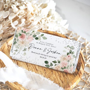 May include: A white chocolate bar wrapper with a floral design and the text "Love, Laughter & Happily Ever After! Donna & Joshua Thank you for sharing our special day! 06.24.24"