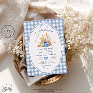 May include: A rectangular baby shower invitation card featuring a light blue and white gingham border. The center displays a cartoon bear, a blue gingham pumpkin, and wheat stalks. Text reads: A little Pumpkin is on the way! Kaitie and Michael.