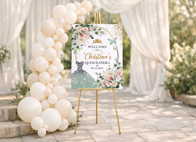 May include: A welcome sign for Christina's Quincea&ntilde;era, featuring a gold easel. The sign displays text and a dress illustration, surrounded by floral and butterfly accents. A balloon arch and draped fabric create a festive backdrop.