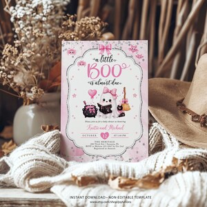 May include: A rectangular baby shower invitation card featuring a pink and white theme with a ghost illustration, a black cauldron, a broom, and a heart-shaped balloon. The text reads a little BOO is almost due, honoring Kaitie and Michael.