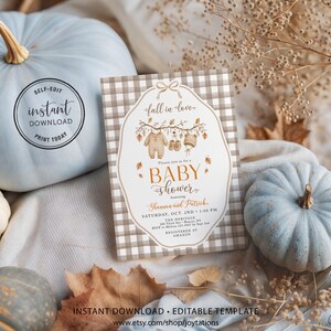 May include: A rectangular baby shower invitation card featuring a beige and white buffalo check border. The center displays a white label shape with a bow, autumn leaves, and baby clothes illustrations. Text includes fall in love, BABY SHOWER, and event details.