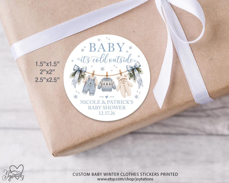 May include: A round white sticker featuring the text BABY it's cold outside, Nicole & Patrick's Baby Shower, and 12.17.26. The design shows baby clothes on a clothesline with blue bows, snowflakes, and available sizes 1.5x1.5, 2x2, and 2.5x2.5 inches.