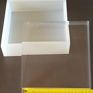 May include: Two clear plastic boxes, one inside the other. The larger box is 20 inches long and the smaller box is 11 inches long.